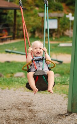 Baby schaukelt am Spielplatz